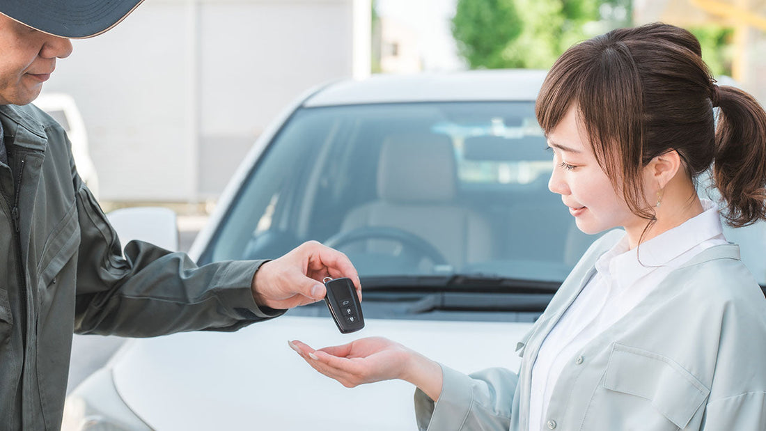 A Lakeside advisor handing loaner car keys to a customer outside a clean modern collision center