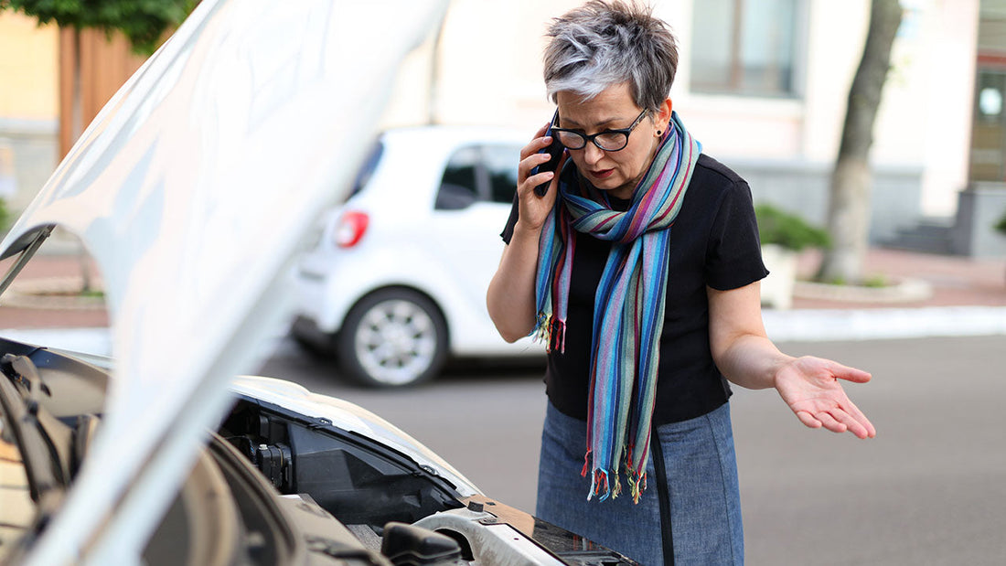 Driver outside a collision repair shop reviewing an insurance policy after learning they have no rental car coverage