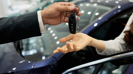 A driver picking up a rental car while their vehicle is being repaired at a collision shop