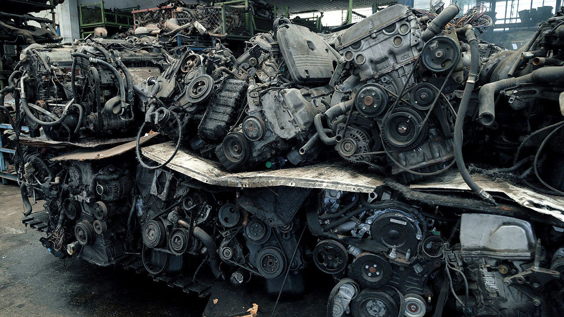Rows of recycled vehicle body panels in a salvage yard next to a technician inspecting a used door in a clean repair bay